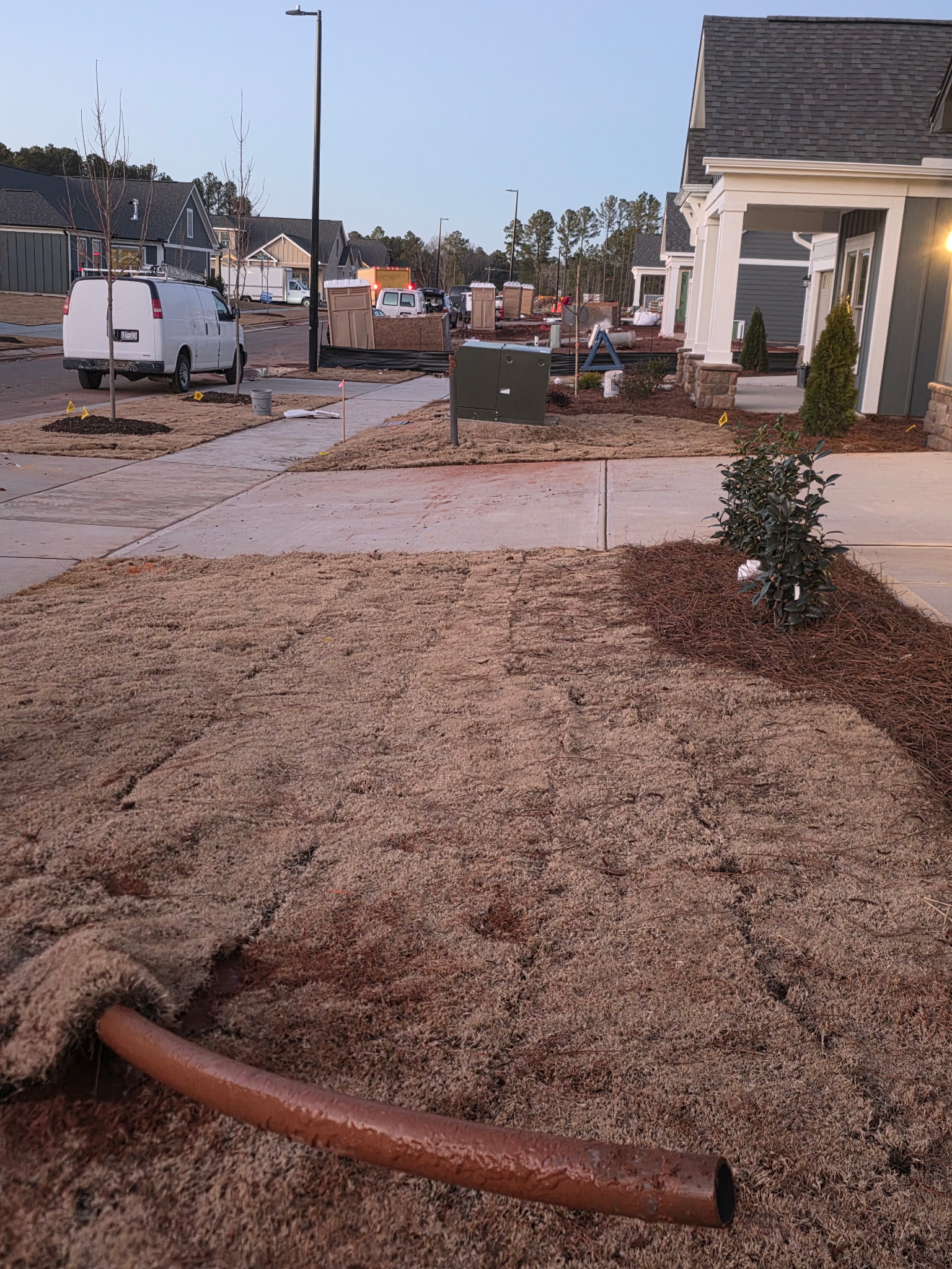 Completed horizontal directional drilling bore with conduit emerging at a residential jobsite